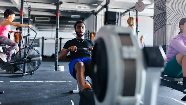 Movement-exercise: man using rowing machine 1497021390