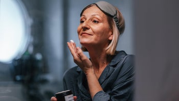 Dermatology: senior woman applying face cream 2080405888