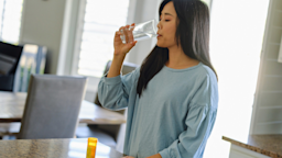 A person taking pills in their kitchen.
RichLegg/E+ via Getty Images 