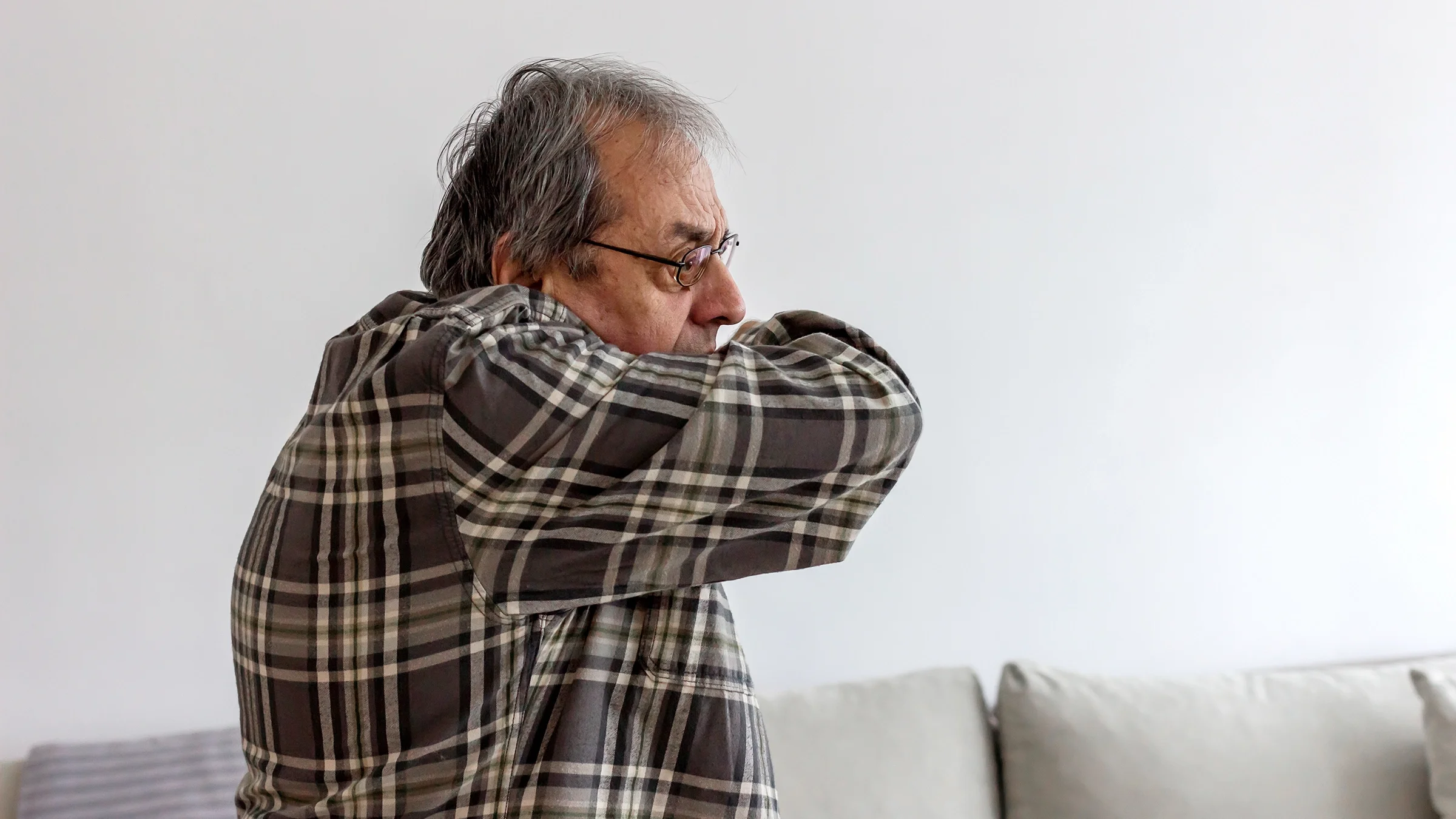Man coughing into his elbow