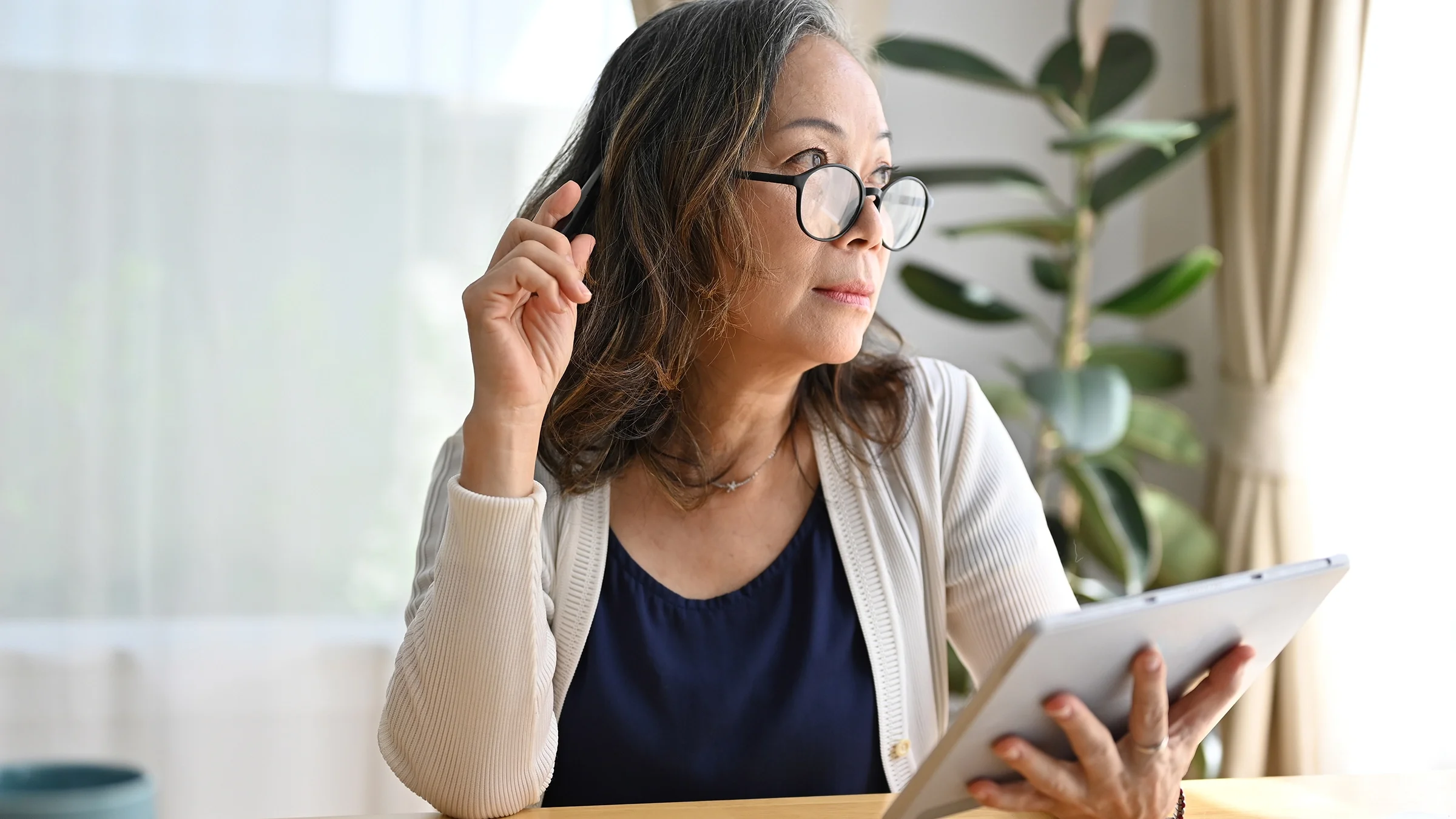 A woman does research on her tablet at home.