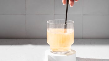 Irritable-bowel-syndrome: closeup mixing powder in glass of water 2168231833