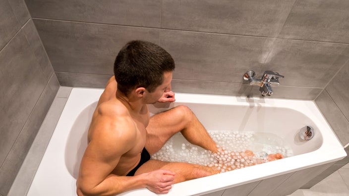 Man laying in ice bath