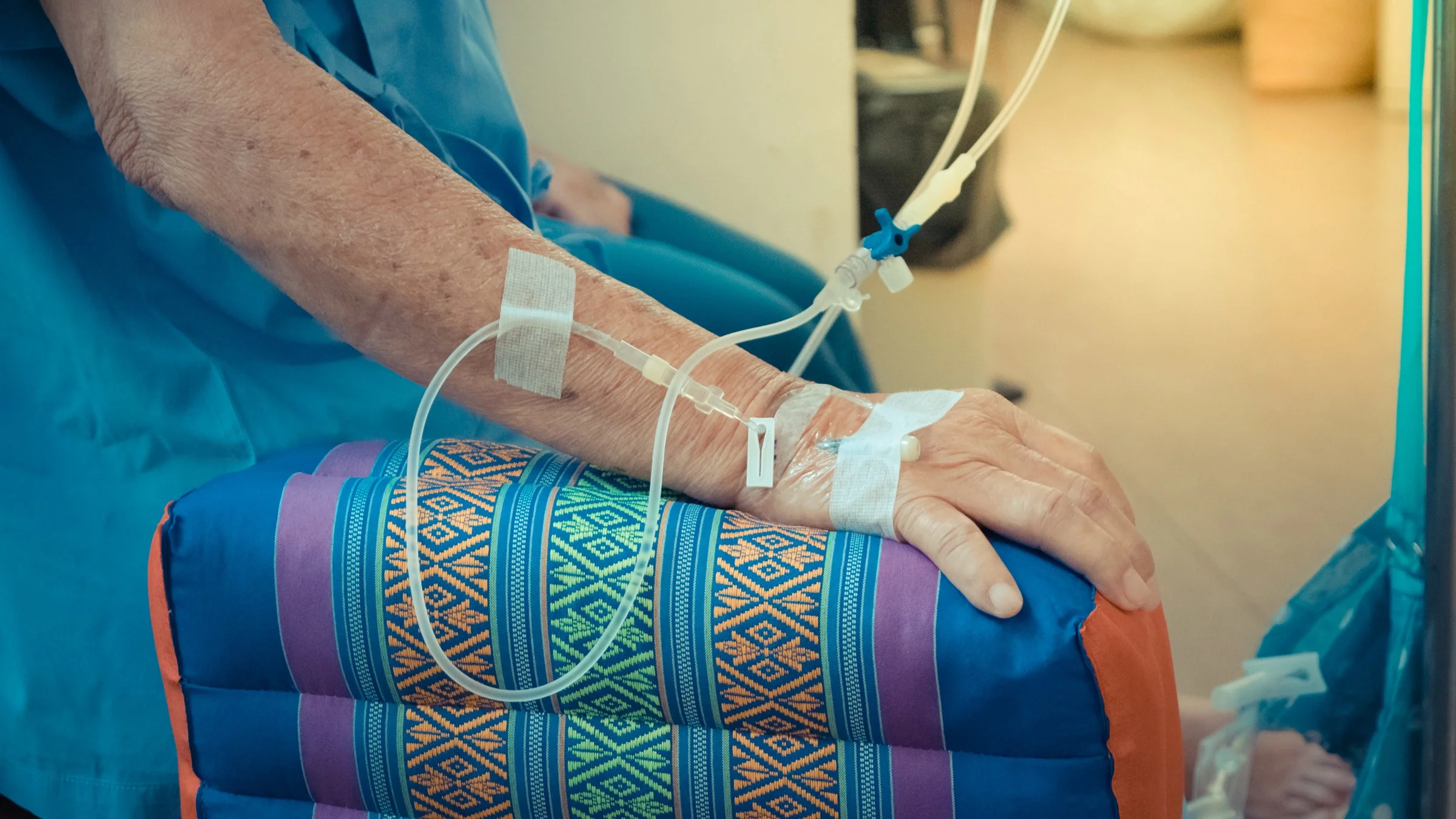 Cropped close-up of someone receiving an IV infusion. 