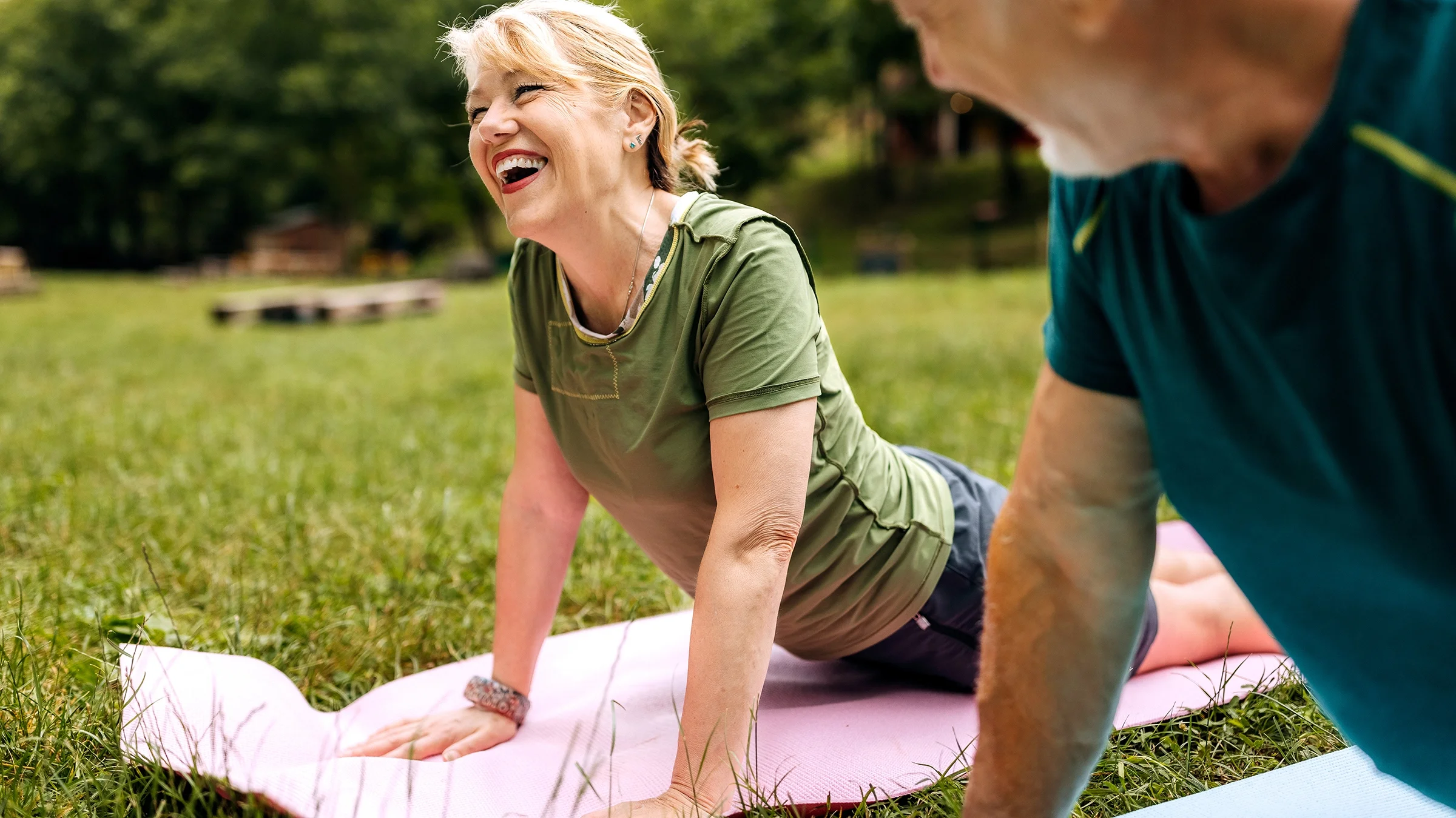 A woman practices yoga during a class outdoors.