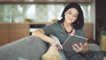 metformin: woman using tablet while siting on couch 894678492