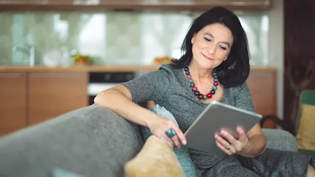 metformin: woman using tablet while siting on couch 894678492