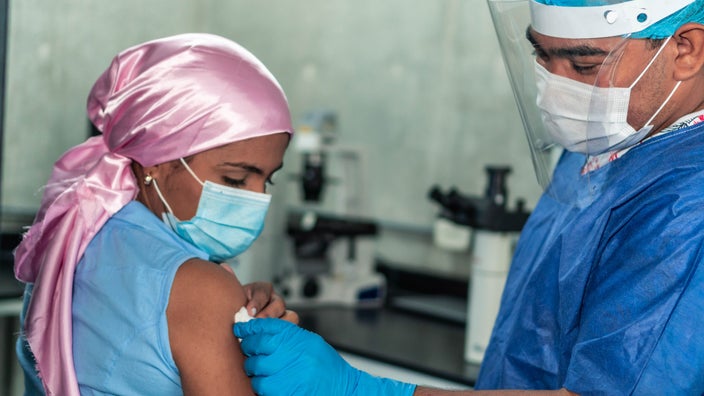 A HCP injecting a cancer patient's arm in preparation for an injection.
