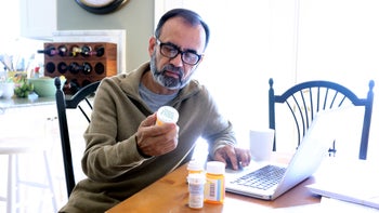 Pharmacy: man researching medication 837648142