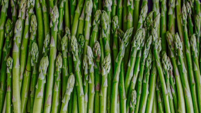 A close-up image displays asparagus. 