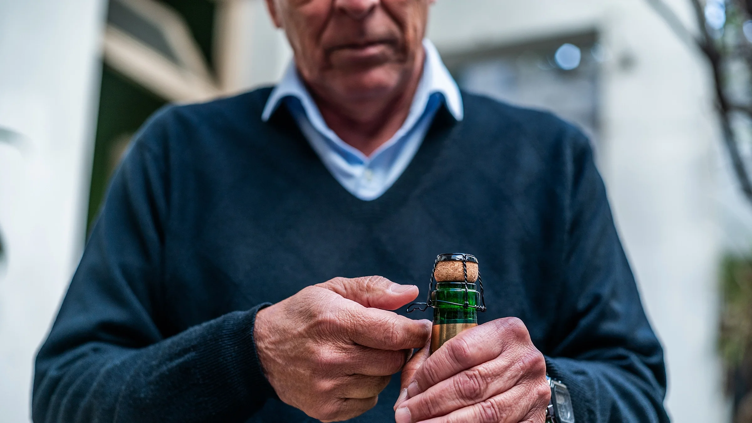 A man opens a bottle of champagne.