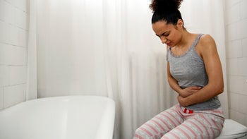 constipation: woman sitting on toilet with stomach pain 1425552409
