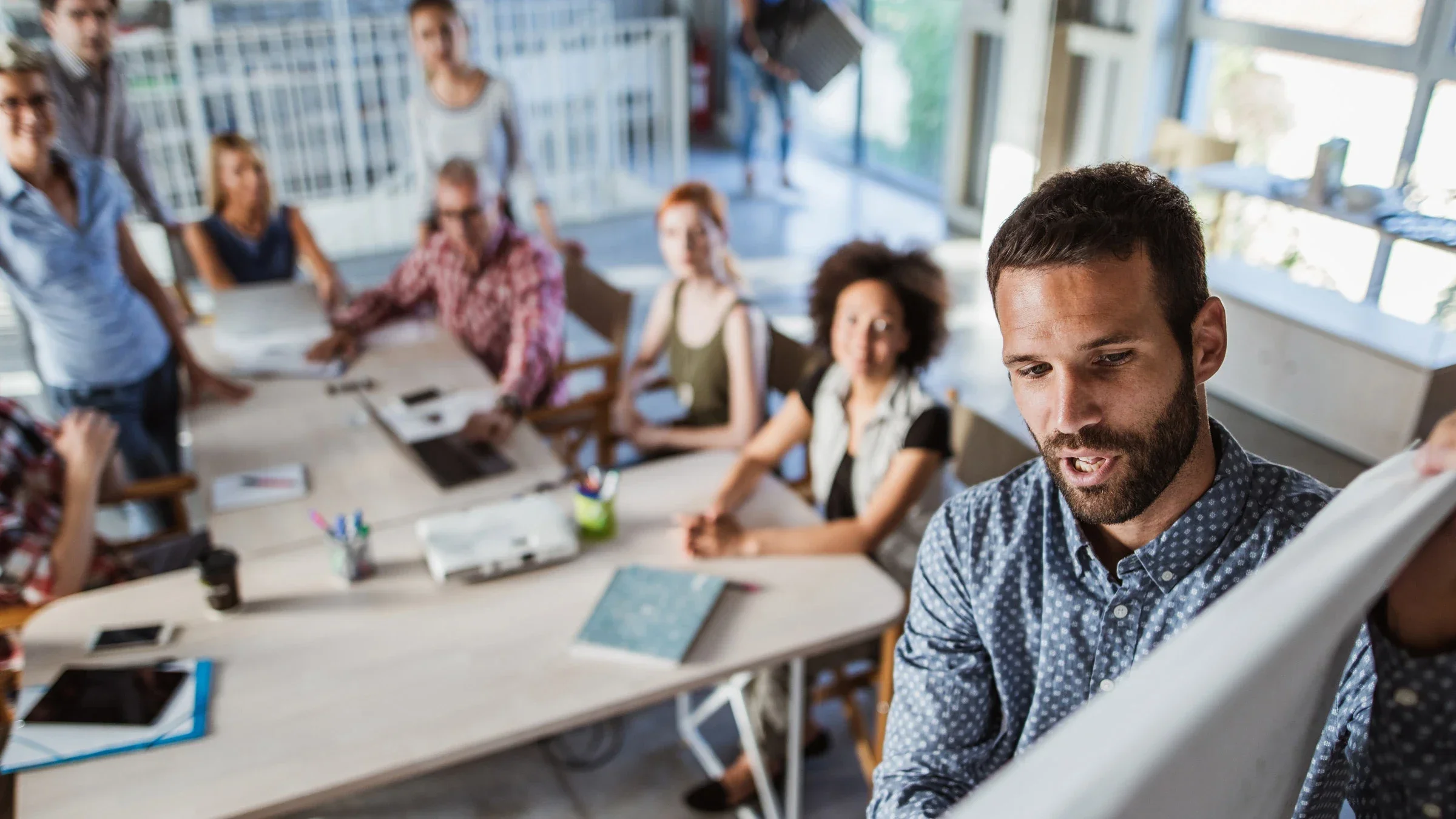 A person making a business presentation in front of blurred colleagues.
skynesher/E+ via Getty Images 