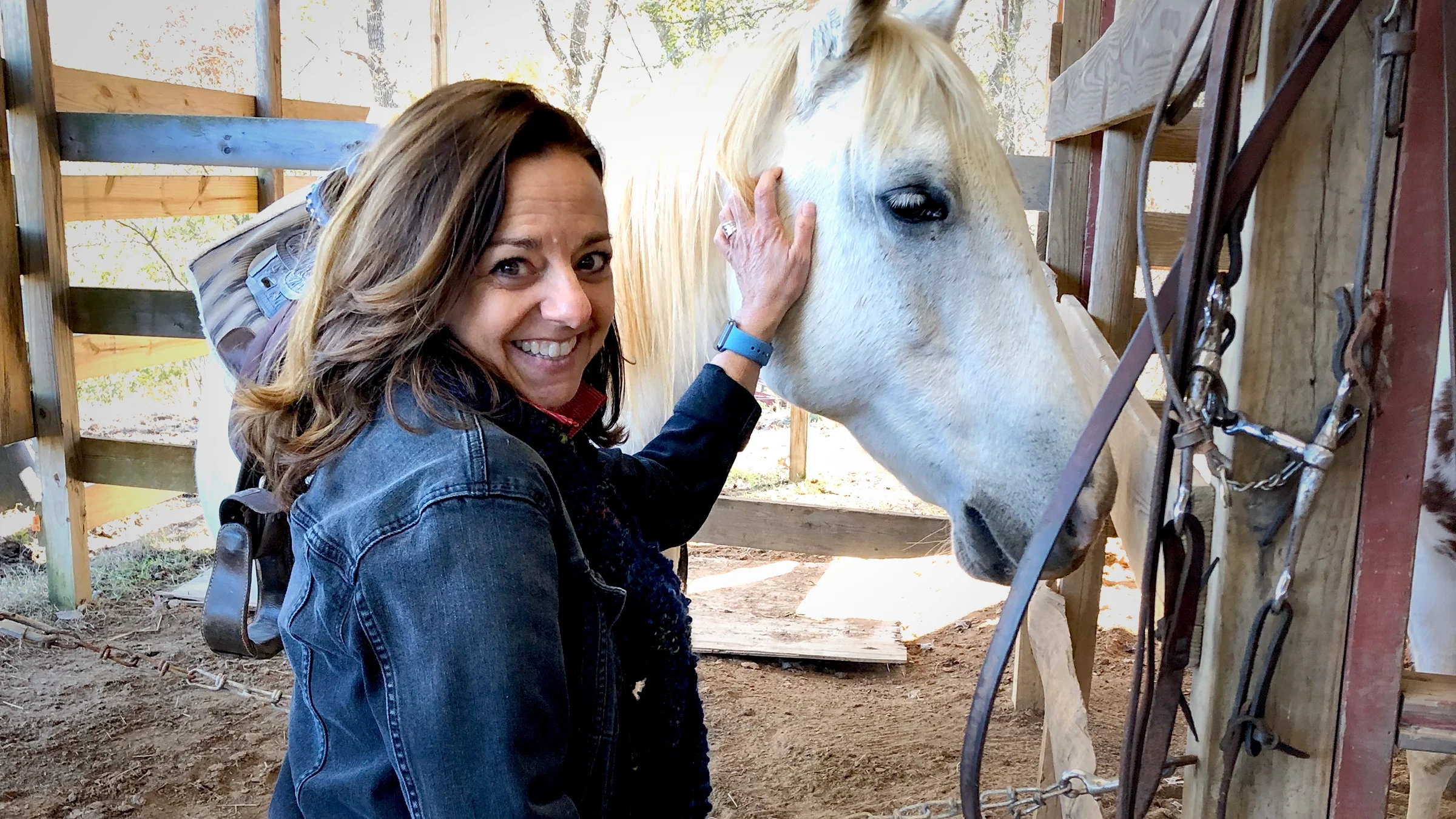 Jill DuBois beside a white horse. She found that equine therapy helped her deal with challenging health conditions.
