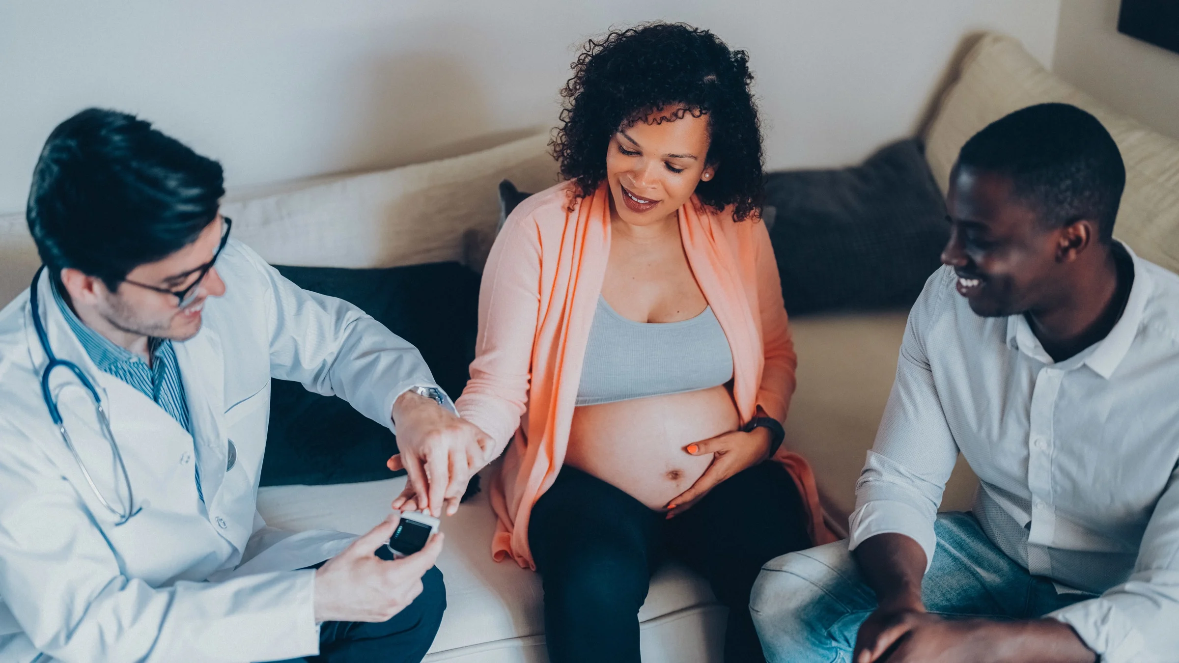 A doctor taking a pregnant patient's blood sugar.