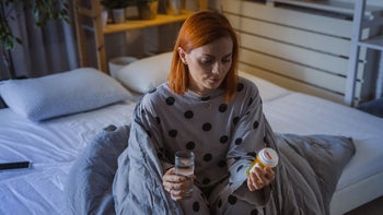 quviviq: woman in bed with pill bottle 1745085953