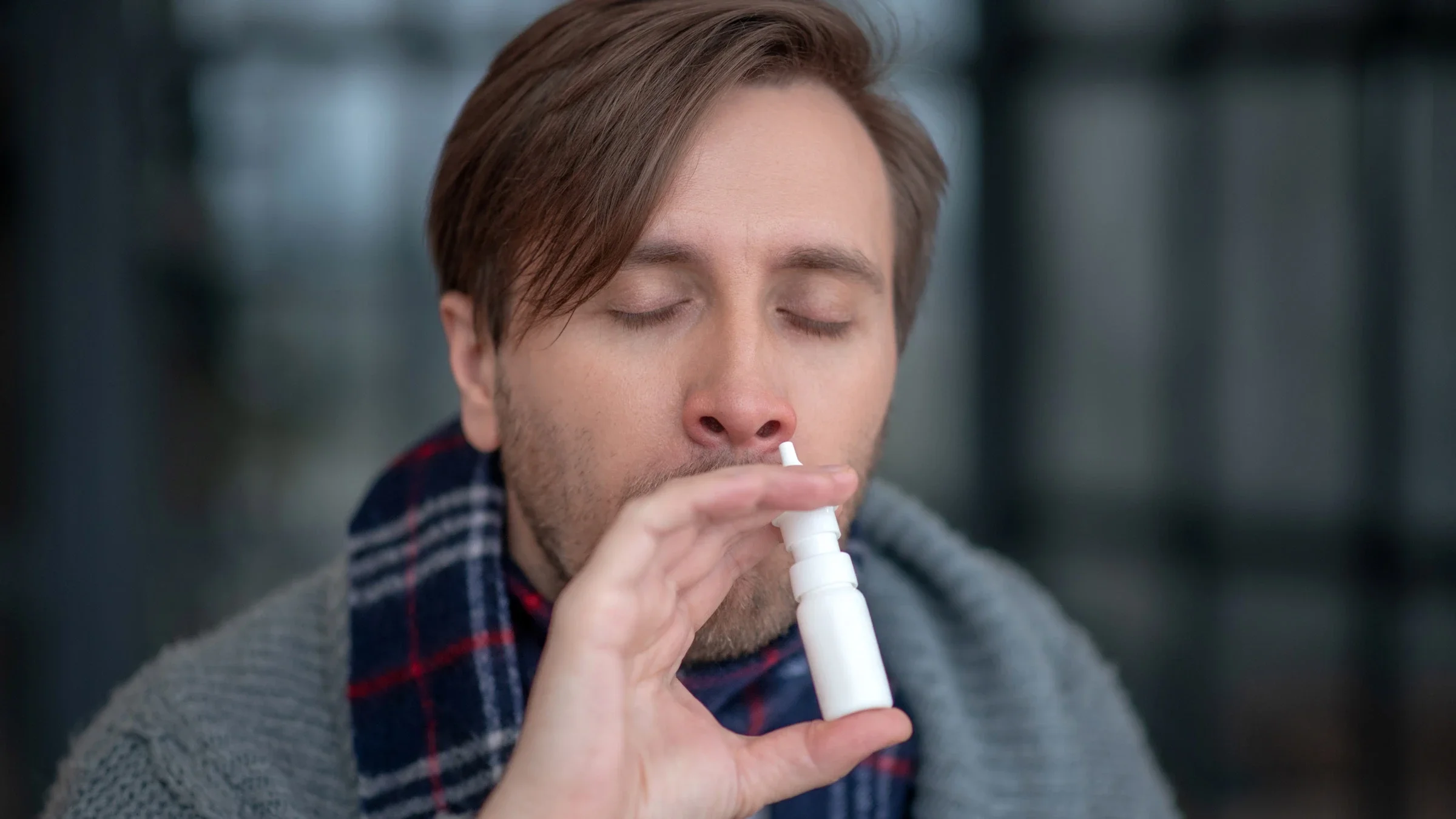 A person using nasal spray.