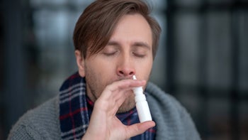 Health: Covid-19: person using nasal spray 1182063091