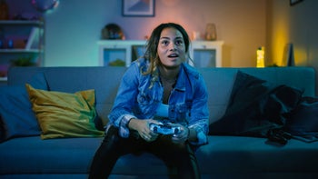 Health: Addiction: gamer on couch playing video game 1157289849