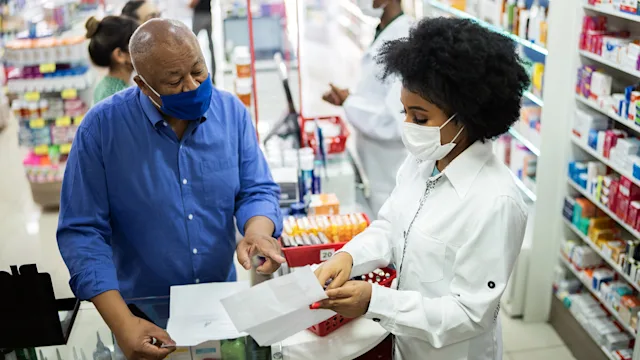 Medication education: senior man speaking to pharmacist 1344253276