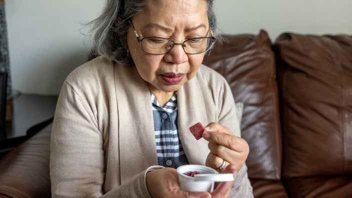 Older woman eats a cannabis gummy