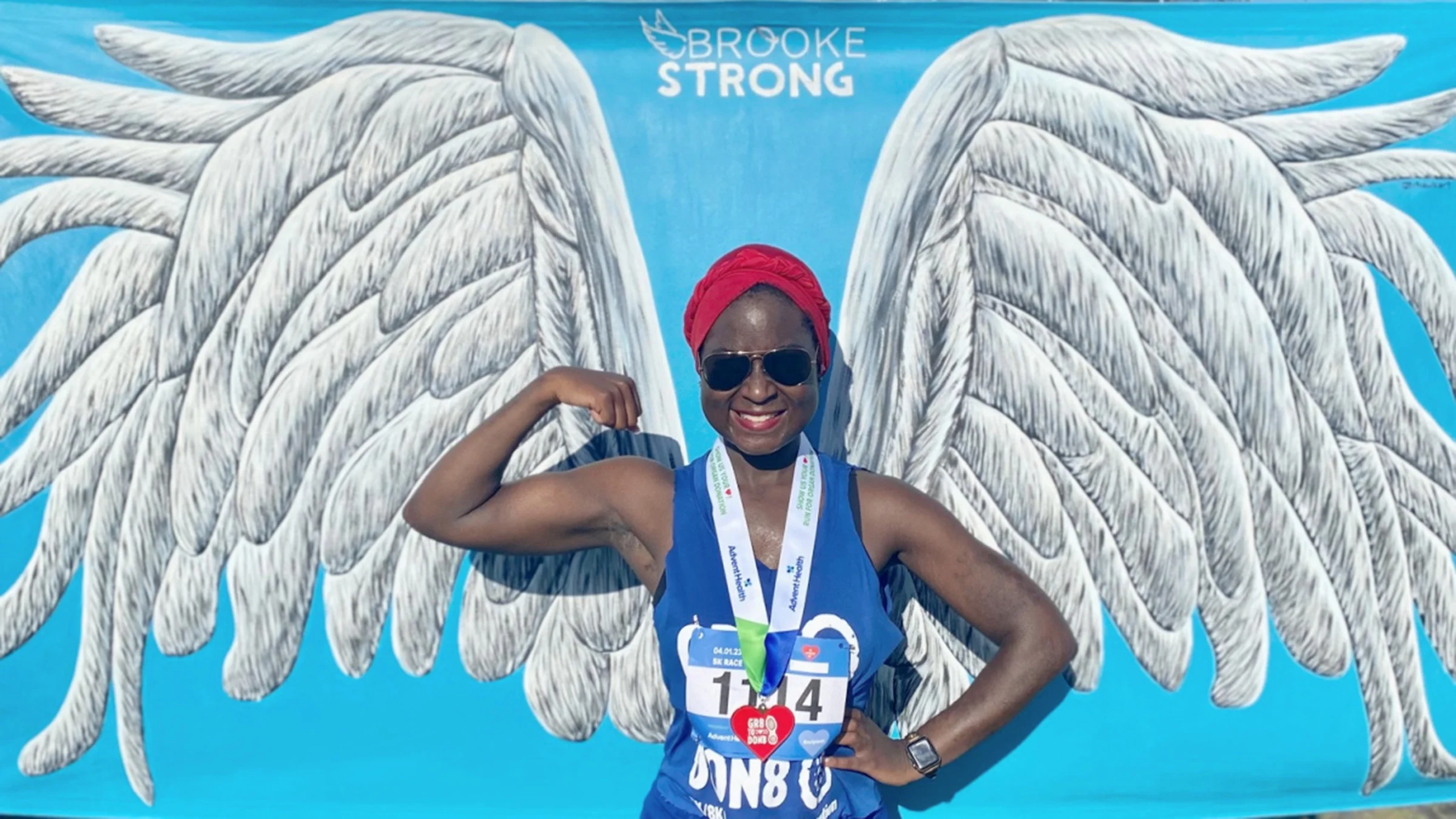 Gabrielle Davis is pictured in front of a wings illustration after running a 5K.