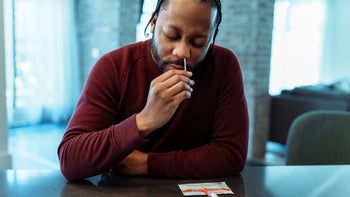 COVID-19: man taking covid test at home 1504335321