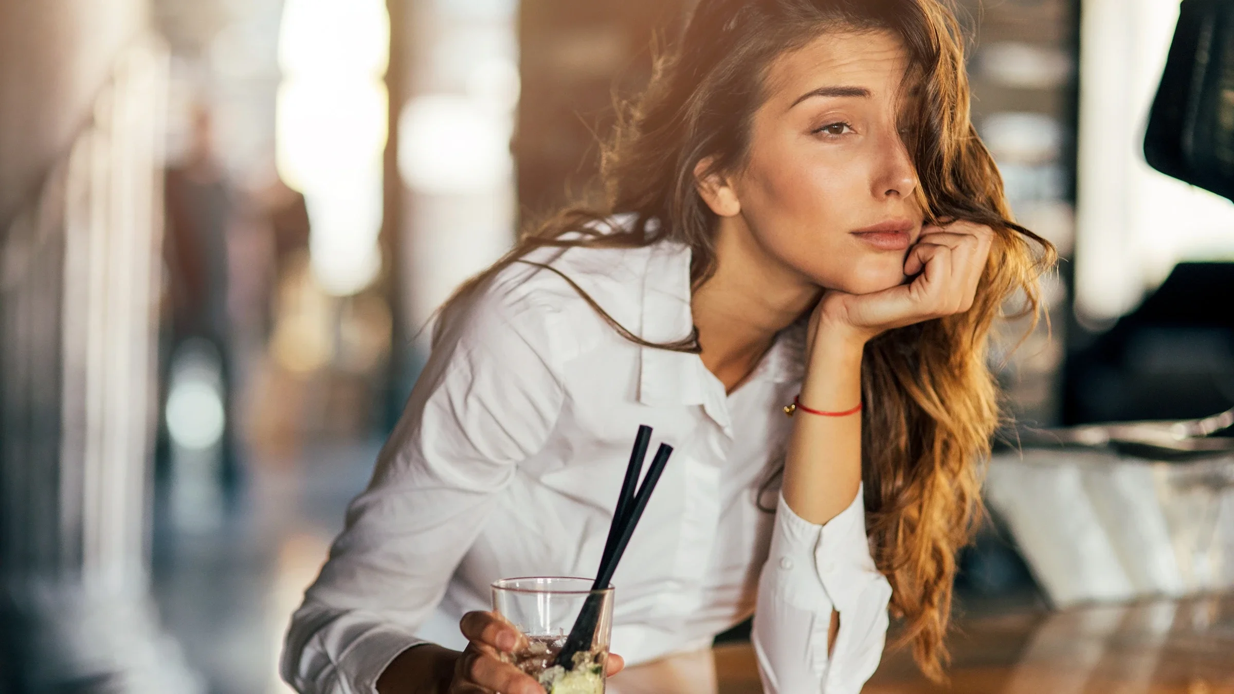 Woman drinking cocktail in a bar with mental fogginess.