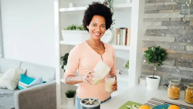 Diet nutrition: Vitamin A: woman pouring smoothie-1277415360