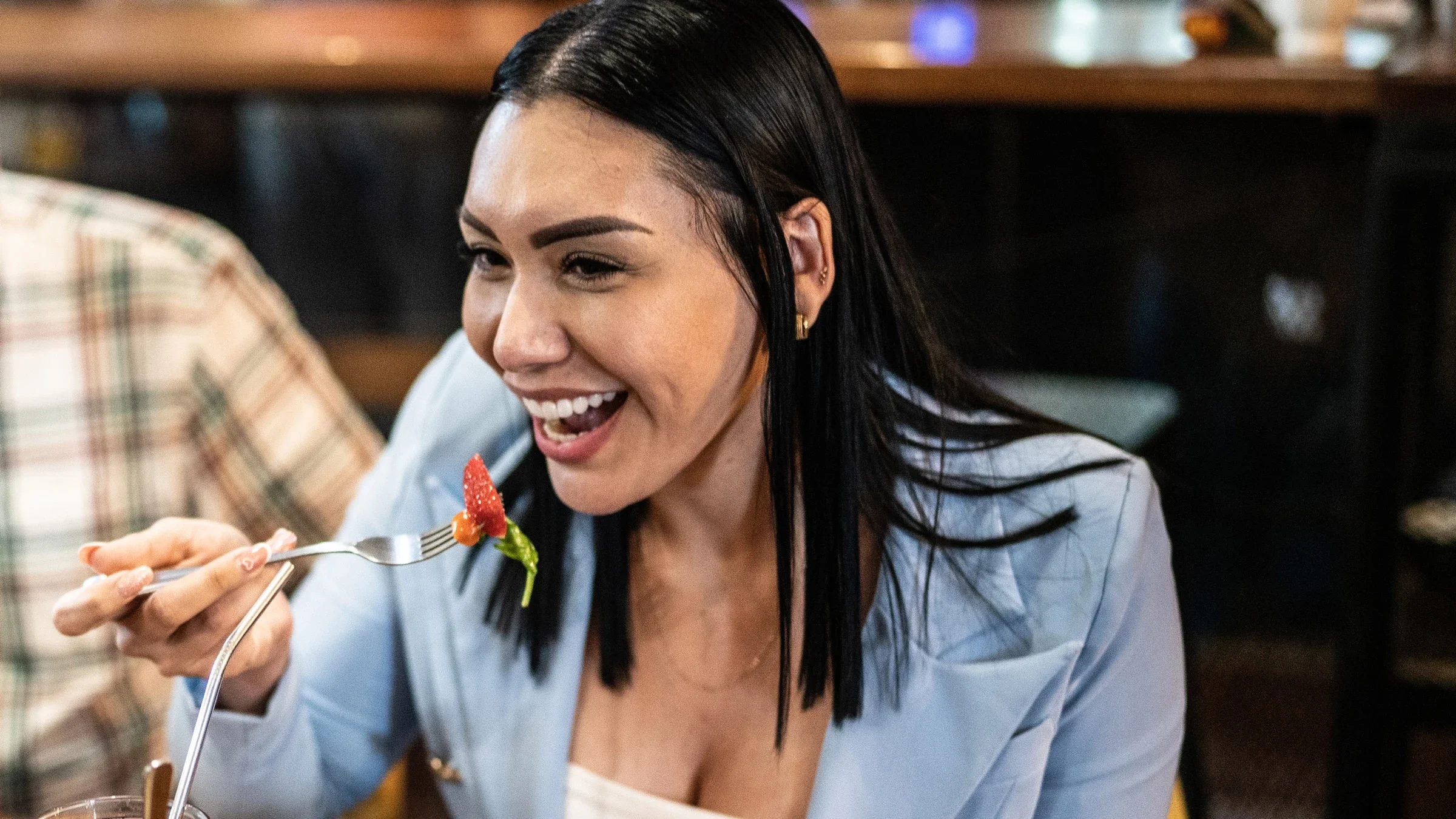 A person bringing a fork full of food to their mouth.