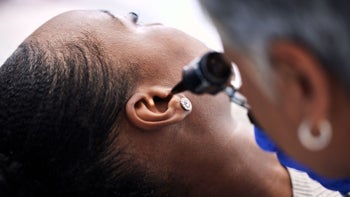 ear infection: closeup doctor checking womans ear 1766555538