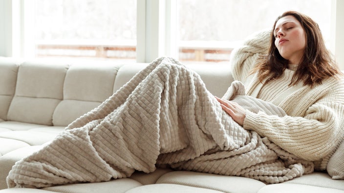 A fatigued person on their couch.