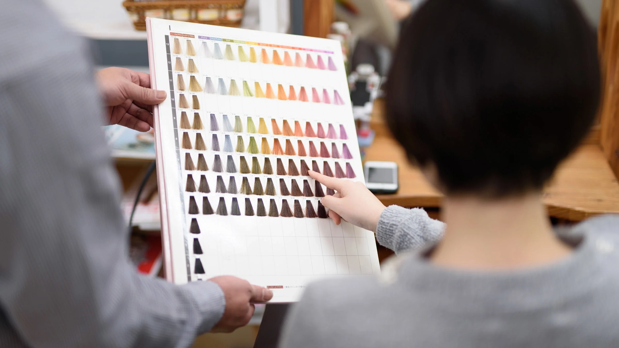 A person choosing a hair color in a salon.