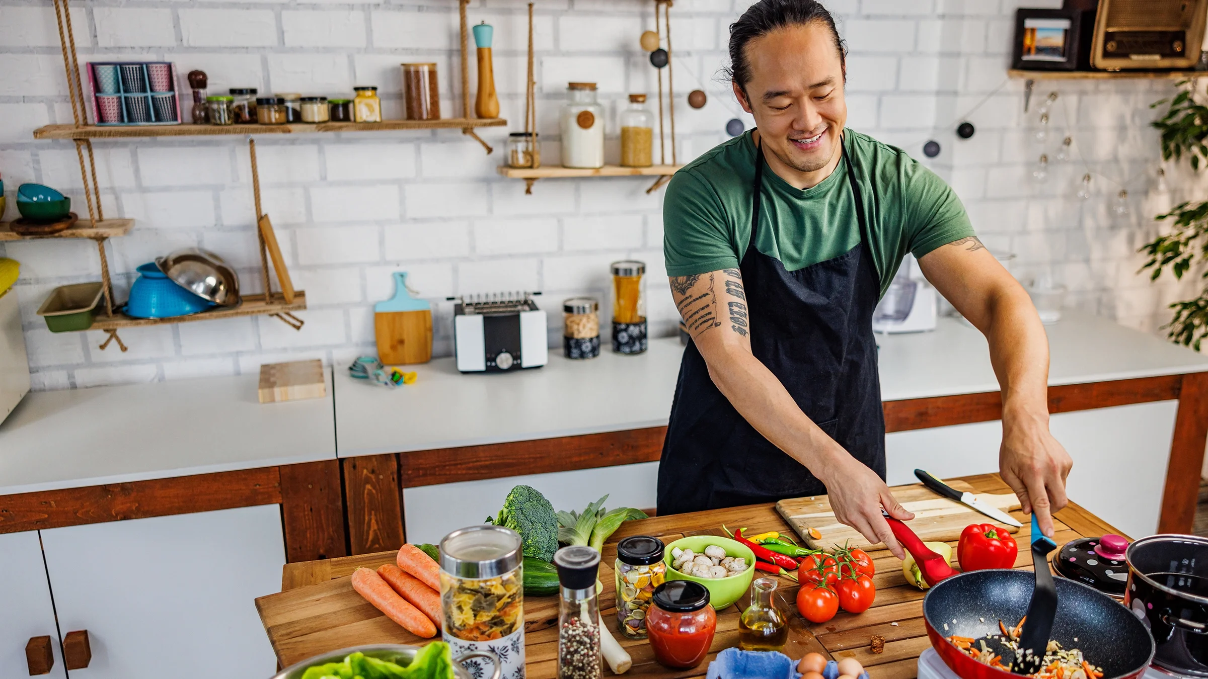 A man cooks vegetables in a pan.