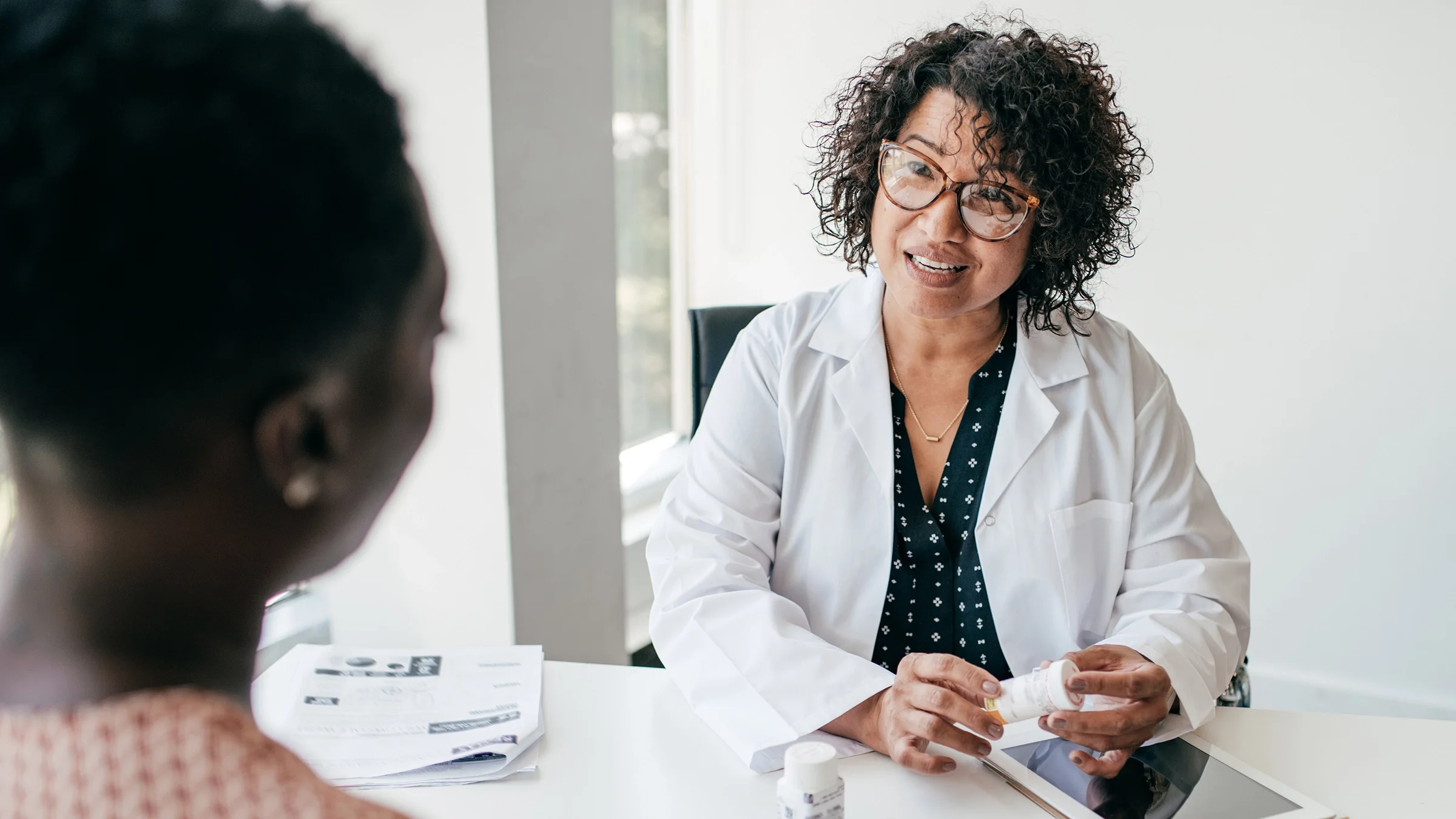 A doctor talks with her patient. People with hidradenitis suppurativa (HS) should talk with their healthcare professional about the best treatment option based on the stage of their skin condition.