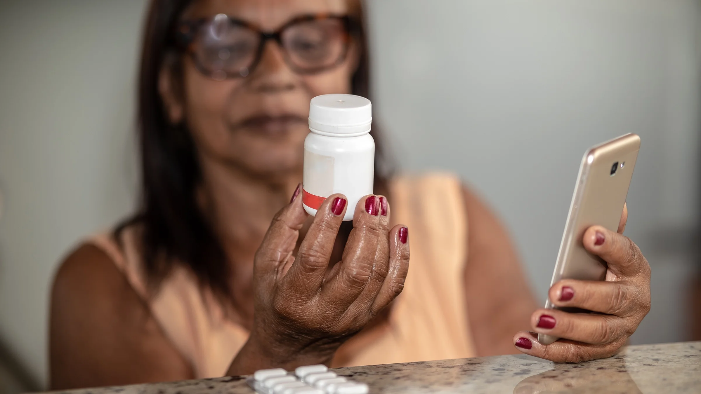 A woman looks up a medication using a mobile phone.
