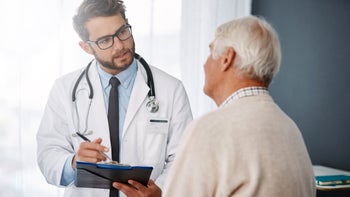 Medicare: doctor speaking to senior patient 985524096