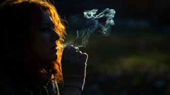 Smoking: woman smoking cigarette in park 1289138121
