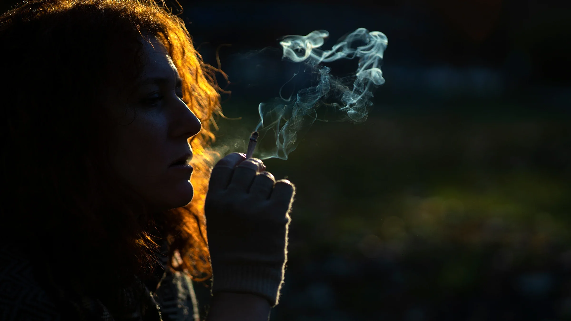 A woman smokes a cigarette at the park.
taseffski/E+ via Getty Images