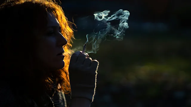 Smoking: woman smoking cigarette in park 1289138121