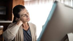 A woman clutches her neck in pain.
FG Trade/E+ via Getty Images