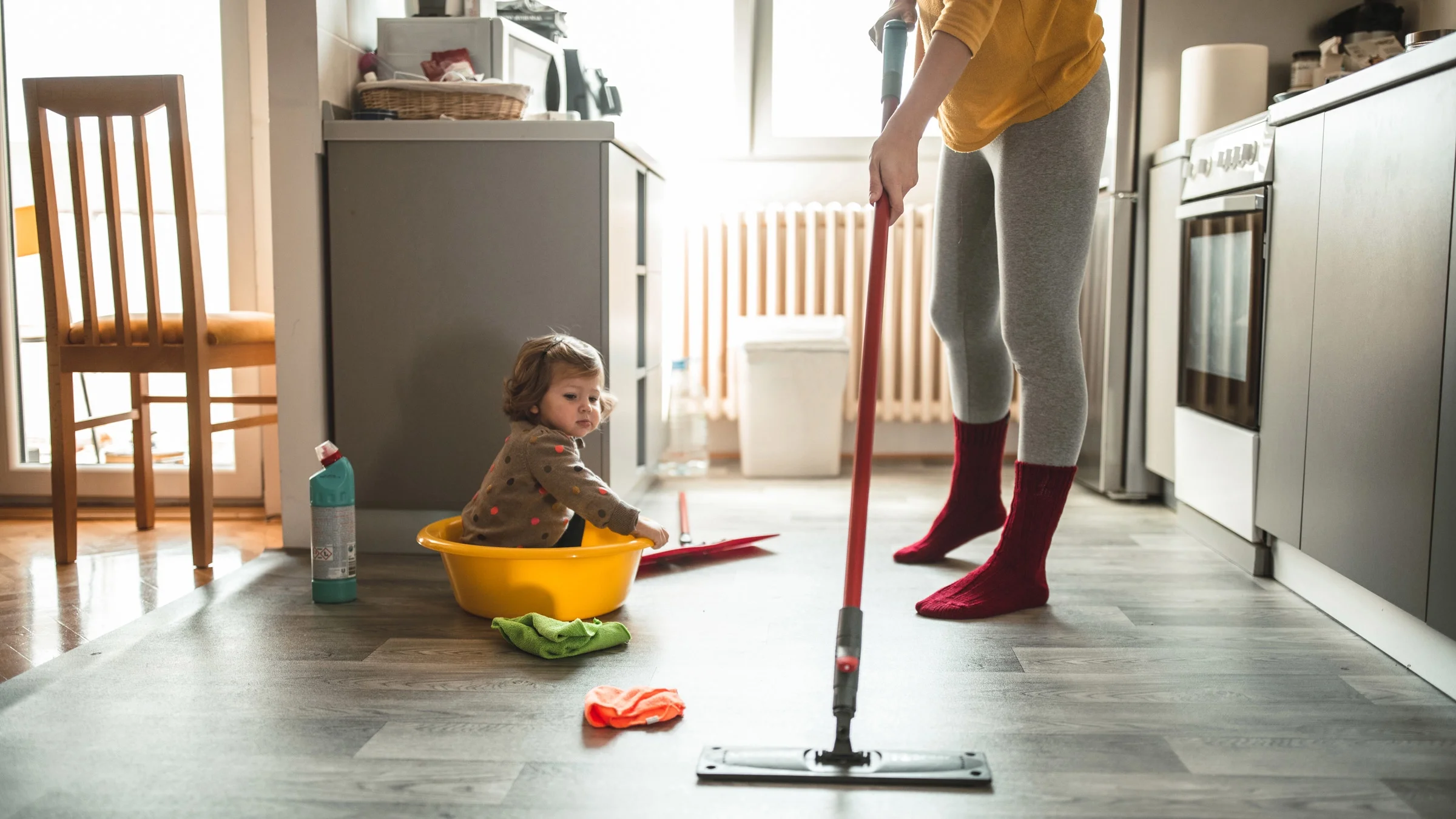 A child watching their parent mop.