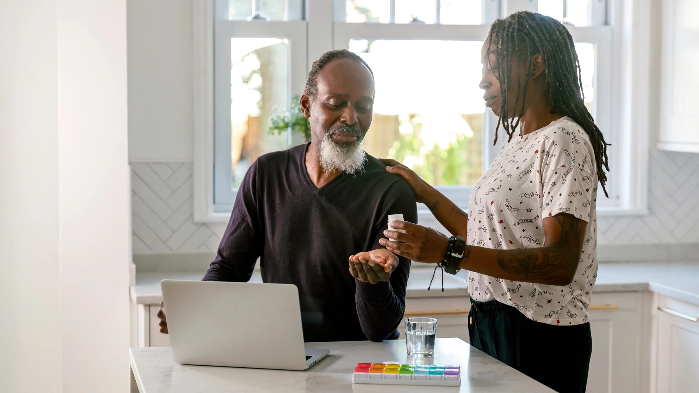 A couple in kitchen taking daily medication