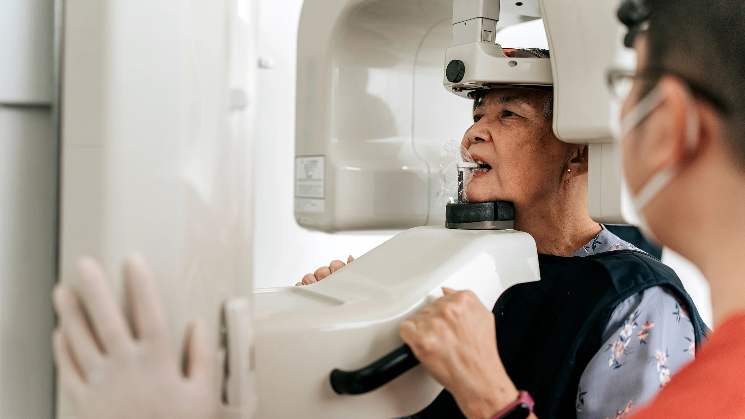 A woman gets a dental X-ray, which can help identify and confirm a tooth cavity.
