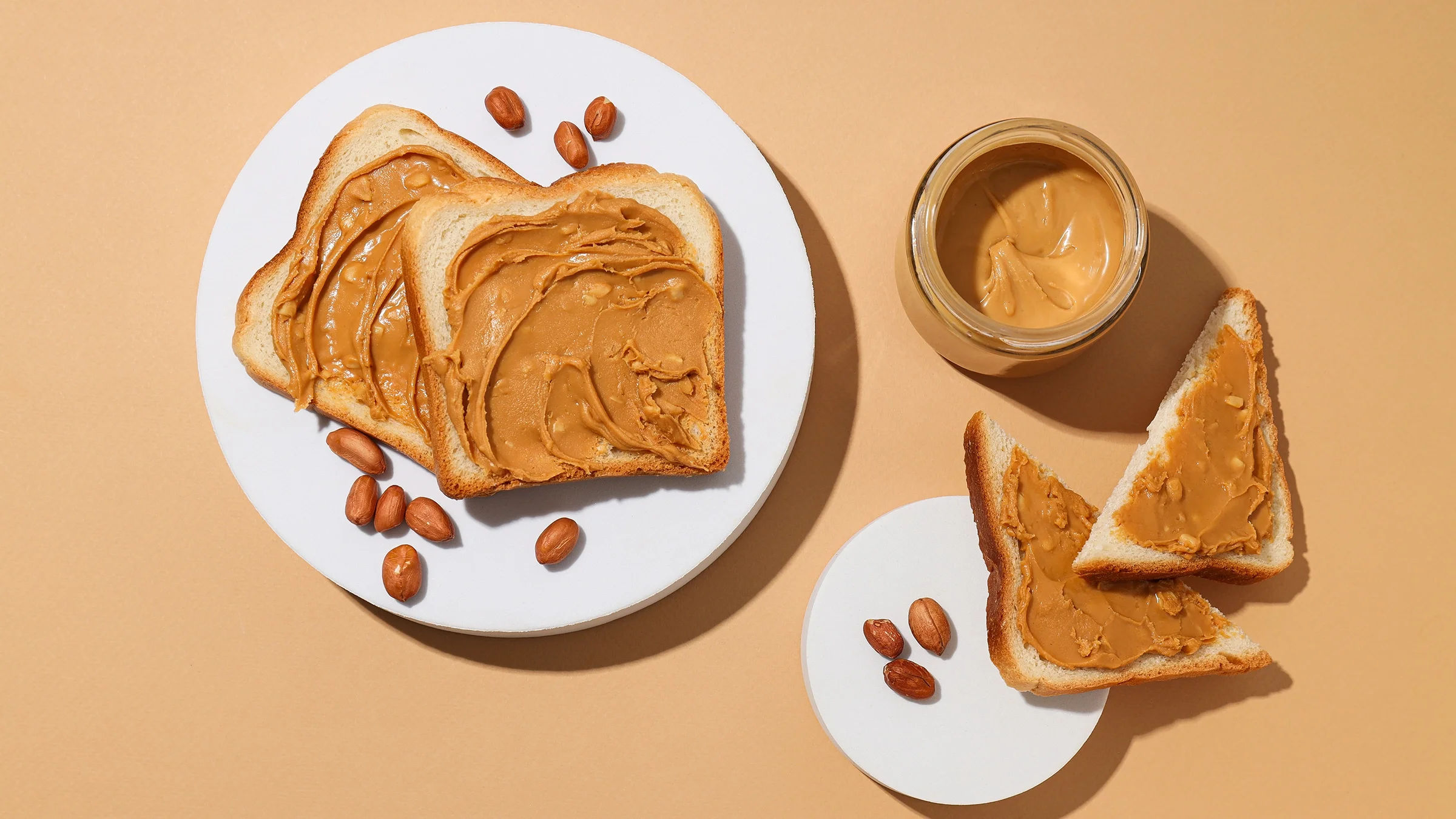 Jar of peanut butter with toast on a light background