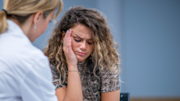 Woman looking distressed while talking to therapist.
FatCamera/E+ via Getty Images