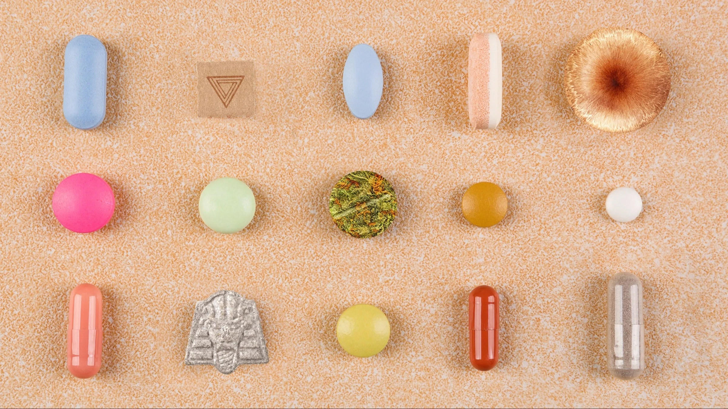 Various hallucinogenic pills on a textured tan background.