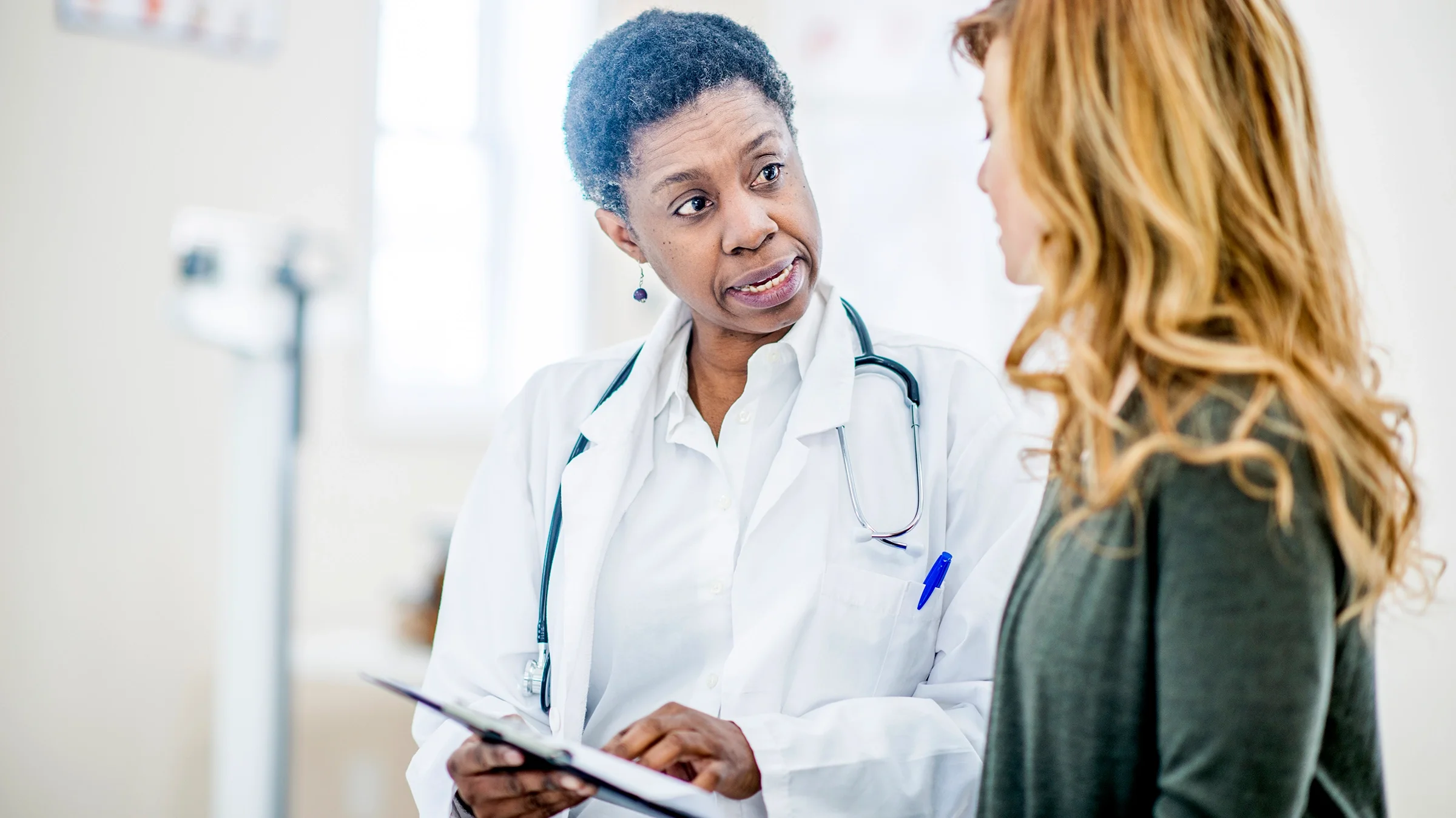 A doctor discusses medical information with a female patient.
