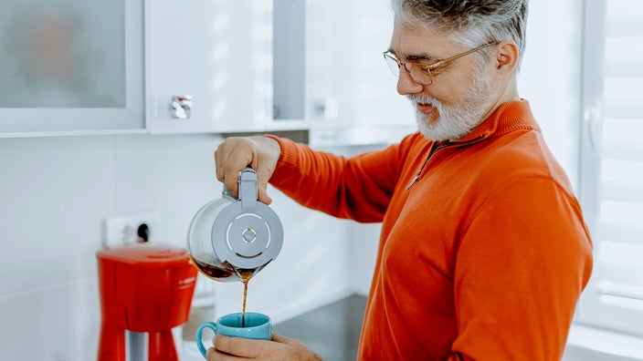 Man pouring coffee into a mug.