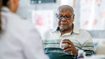 Health: Carbidopa/levodopa: senior man with Rx bottle 1134340766